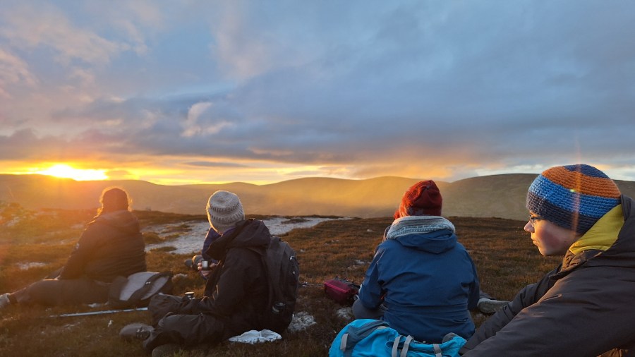 Group on a hilltop at sunset